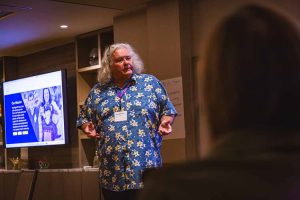 man speaking to people seated