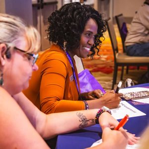 two ladies writing at table