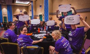 people sitting around table holding signs